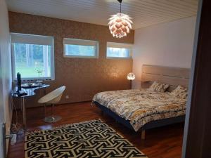 um quarto com uma cama, uma mesa e janelas em Villa Kilpäkki em Pori