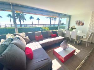 a living room with a couch and a table at Magnifique appartement les pieds dans l’eau à Nice in Saint-Laurent-du-Var