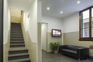 a lobby with a staircase and a black leather couch at Loggia Fiorentina in Florence