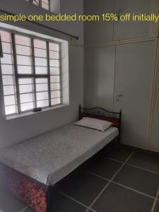 Cama pequeña en habitación con 2 ventanas en White Corner House, 2/14, Goverdhan Vilas, Housing Board Colony, Udaipur 313002 en Udaipur