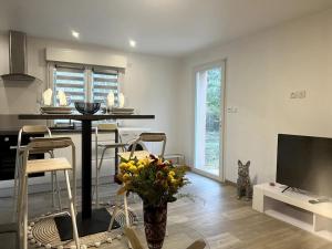 a living room with a table with chairs and a television at Entre mer et Montagne in Prades