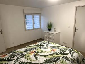 a bedroom with a bed and a dresser and a window at Entre mer et Montagne in Prades