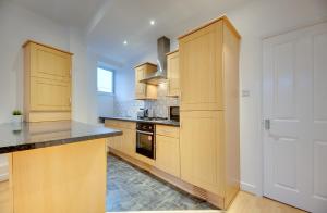 een keuken met houten kasten en een aanrecht bij Armstrong Apartments by Week2Week in Newcastle upon Tyne