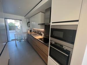 una cucina con elettrodomestici in acciaio inossidabile e bancone di Ocean View Top Luxury New Built T2 -WPOV2 a Cabanas de Tavira