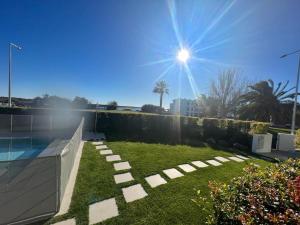 un patio trasero con césped y piscina en Ocean View Top Luxury New Built T2 -WPOV2, en Cabanas de Tavira
