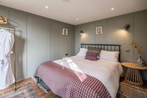 a bedroom with a large bed and a table at Toad Hall Lodges - Luxury Eco Lodges Near Southwold! in Wangford