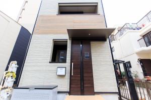a house with a wooden door on a street at 森の物語 in Nagoya