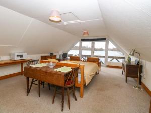 a bedroom with a bed and a table with a desk at Cygnus Boathouse in South Walsham
