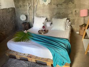 Una cama grande con una mesa encima. en Macaronesia Love Spa, sauna y piscina en Buzanada