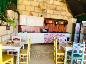 een keuken met witte kasten en tafels en stoelen bij Macaronesia Love Spa, sauna y piscina in Buzanada