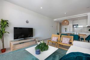 sala de estar con TV, sofá y sillas en Luxury 2bed apartment Mirador del Golf, Estepona, en Estepona