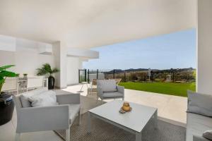 sala de estar con muebles blancos y mesa en Luxury 2bed apartment Mirador del Golf, Estepona, en Estepona