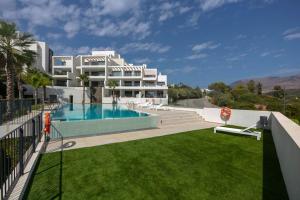 un gran edificio blanco con piscina y patio en Luxury 2bed apartment Mirador del Golf, Estepona, en Estepona