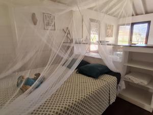 a bedroom with a bed with a mosquito net at Les lofts Edouard in Terre-de-Haut