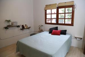 a bedroom with a bed with a red pillow on it at Florinda in San Salvador de Jujuy +17 photos