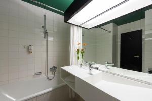 a bathroom with two sinks and a mirror at Wyndham Garden Donaueschingen in Donaueschingen