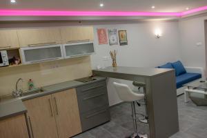 a kitchen with a sink and a table with a stool at Gogolapartman Tisza in Szeged +8 photos