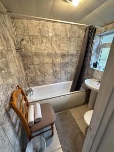 uma casa de banho com uma banheira, um WC e um lavatório. em Luton Town House Near AIRPORT em Luton