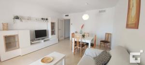 a white living room with a table and a television at Apartamento Ambar Beach 18D - Grupo Turis in Calpe