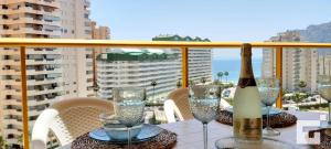 a table with a bottle of wine and glasses on a balcony at Apartamento Ambar Beach 18D - Grupo Turis in Calpe
