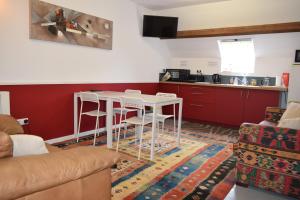 a living room with a table and a kitchen at Appartement Privé, Camping La Pointe in Châteaulin