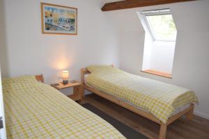 two twin beds in a room with a window at Appartement 3 chambres, Camping La Pointe in Châteaulin