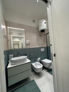 a bathroom with two sinks and a toilet and a mirror at DI PASSAGGIO in Bari