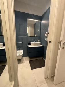 bagno con lavandino, servizi igienici e specchio di DI PASSAGGIO a Bari