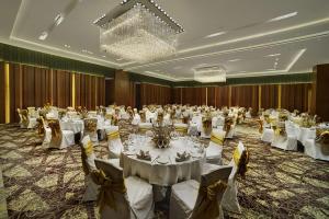 un gran salón de banquetes con mesas y sillas blancas en Hyatt Regency Amritsar, en Amritsar