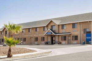 un bâtiment avec un palmier en face dans l'établissement Travelodge by Wyndham Yuma, à Yuma