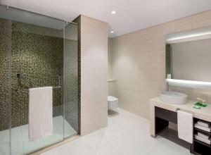 a bathroom with a shower and a sink and a toilet at Hyatt Place Dubai Jumeirah in Dubai