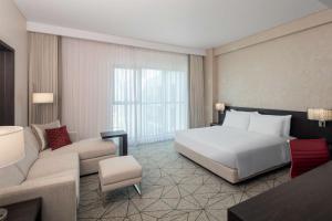 a hotel room with a bed and a couch at Hyatt Place Dubai Jumeirah in Dubai