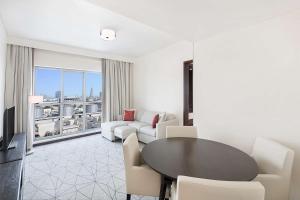 a living room with a table and chairs and a large window at Hyatt Place Dubai Jumeirah in Dubai