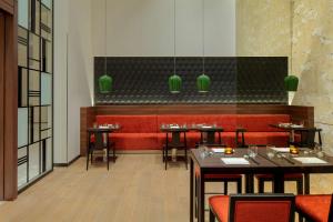 a dining room with tables and red seats at Hyatt Place Dubai Jumeirah in Dubai