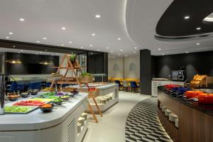 a restaurant with a buffet line with food on display at Hyatt Place Dubai Jumeirah in Dubai