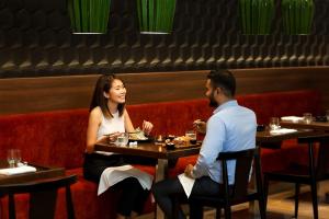 a man and a woman sitting at a table in a restaurant at Hyatt Place Dubai Jumeirah in Dubai