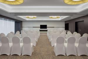 an empty conference room with white chairs and a podium at Hyatt Place Dubai Jumeirah in Dubai