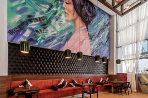 a restaurant with a large painting on the wall at Hyatt Place Dubai Jumeirah in Dubai