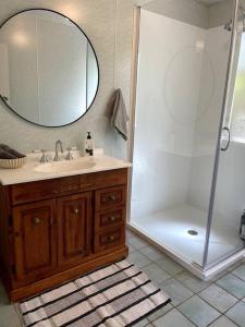 a bathroom with a sink and a shower with a mirror at Cosy Queenslander in the heart of town. in Mareeba