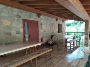 Habitación con mesas de madera y pared de piedra. en Balcón del Aitzgorri, en Mutiloa