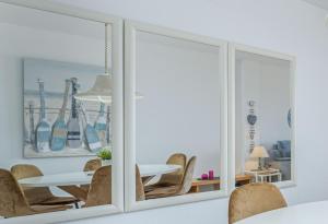 a dining room with mirrors and a table and chairs at Apart-rent Apartamento Mirablau 0085 in Empuriabrava