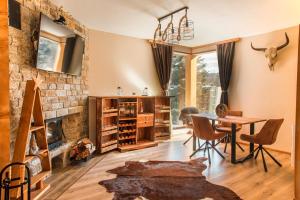 a living room with a table and a fireplace at Forest Lux Boutique Villas in Rakitovo