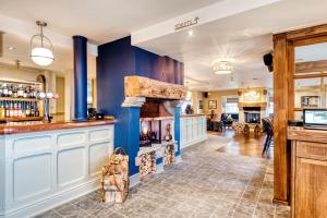 a kitchen with blue walls and a fireplace at The Hand & Sceptre by Innkeeper's Collection in Southborough