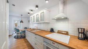 a kitchen with white cabinets and a counter top at Apartamenty Sun & Snow Parkowa in Sopot