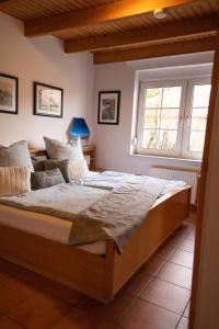 a bedroom with a wooden bed with a window at Tillmann II in Hooksiel mit Hund in Wangerland