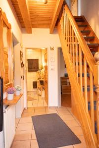 a hallway with a wooden staircase and a living room at Tillmann II in Hooksiel mit Hund in Wangerland