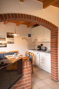 a kitchen with white cabinets and a brick wall at Tillmann II in Hooksiel mit Hund in Wangerland