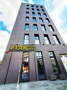 un edificio alto con un cartello con una stella dell'hotel di StarLight Hotel a Tirana