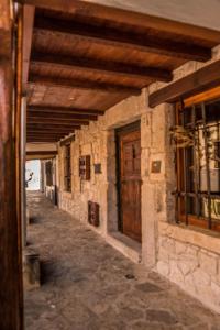 um corredor vazio de um antigo edifício de pedra com uma porta de madeira em El Soportal de Uceda em Uceda