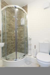 a bathroom with a glass shower with a toilet at Nazarene apartments in Leeds in Stanningley
